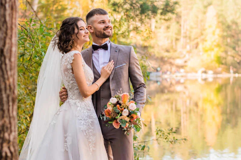 Newlyweds standing in front of Multnomah Falls surrounded by lush green forest